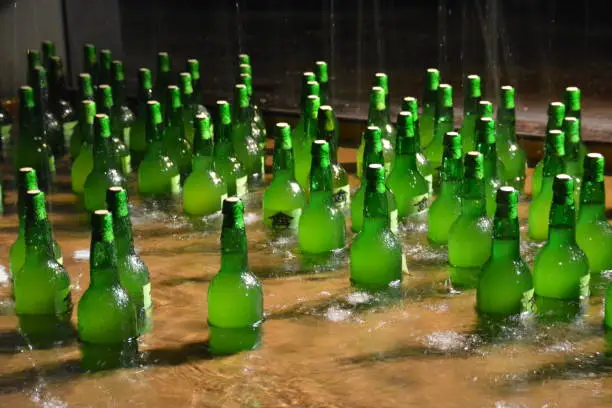 Scene of several bottles of Asturian cider watered with water to maintain the temperature