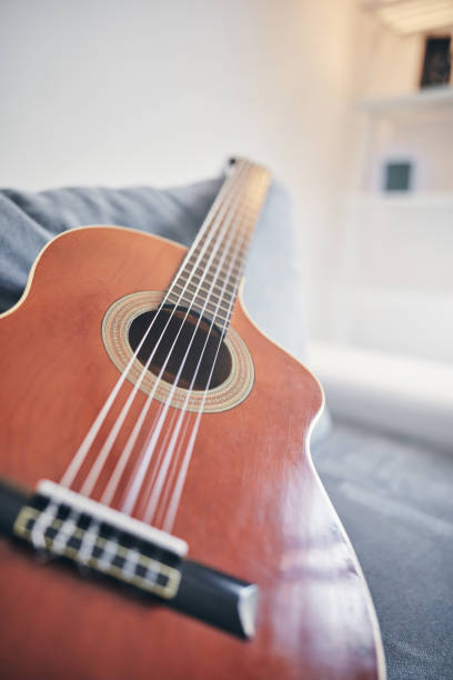 istock Acoustic guitar on a living room couch / sofa. 1167710908