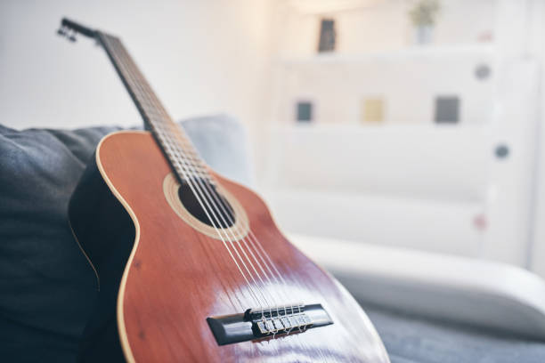 istock Acoustic guitar on a living room couch / sofa. 1167711024