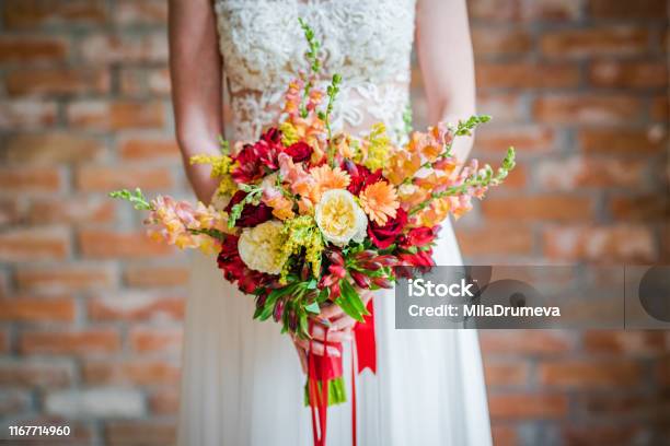 Bride Holding A Beautiful Boho Bouquet Made Of Red And Yellow Fresh Flowers Stock Photo - Download Image Now