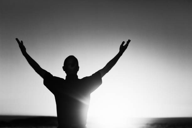 istock Silhouetted man saluting the sun 1167716403