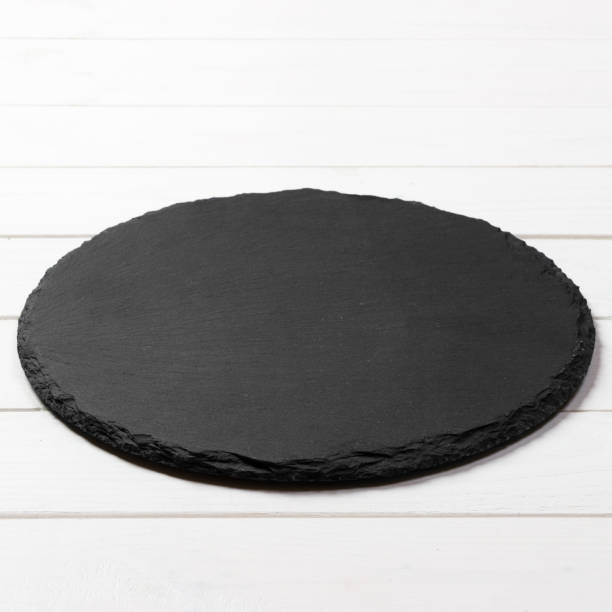 istock Black round plate on wooden background, top view, copy space 1167716834
