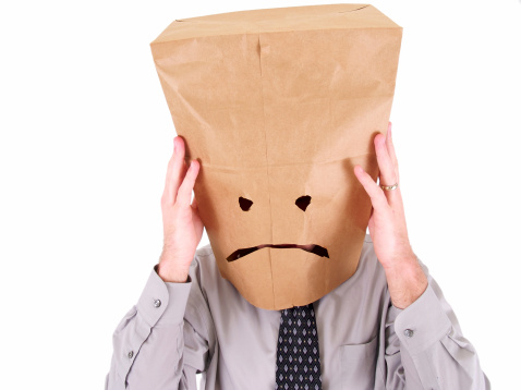 a business worker with a bag on his head isolated on white.