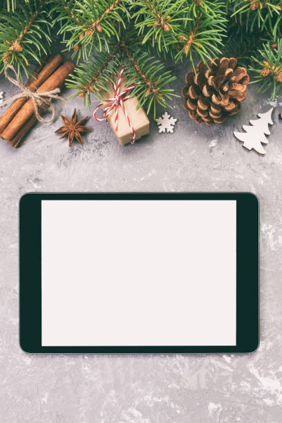 istock Digital tablet mock up with rustic Christmas gray cement background decorations for app presentation. top view with copy space. Toned 1167717380