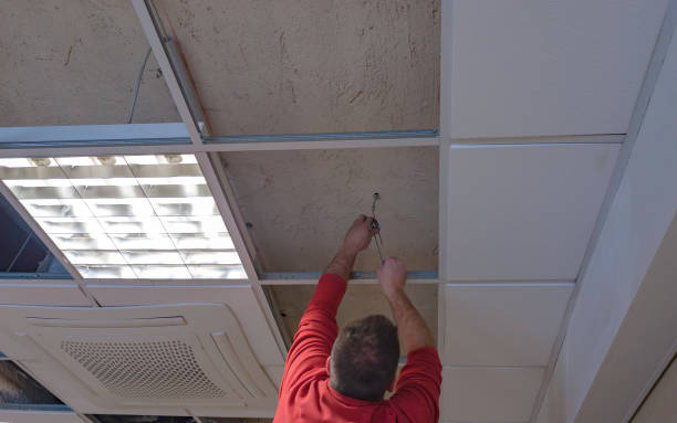 istock Worker repairing board ceiling with gypsum. In the classroom 1167719581