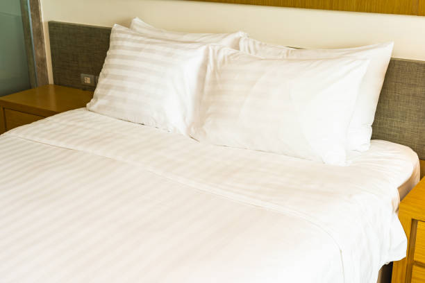 istock White comfortable pillow on bed decoration with light lamp 1167720997