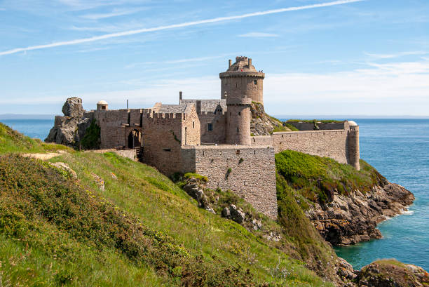 CAP Fréhel Coast on the Bay of Saint-Brieuc with Fort La Latte Cap Fréhel is een landtong aan de Smaragdkust (Côte d'Emeraude) in noordoost Bretagne. Het is het meest noordelijke punt van het rotsachtige voorgebergte tussen de steden Saint-Malo en Saint-Brieuc.Het Fort La Latte werd voltooid in de 14e eeuw door de Bretonse vooraanstaande adellijke familie Goyon of Gouyon-Matignon. headland stock pictures, royalty-free photos & images