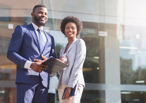 istock Two african american colleagues standing outdoors and looking aside 1167722484