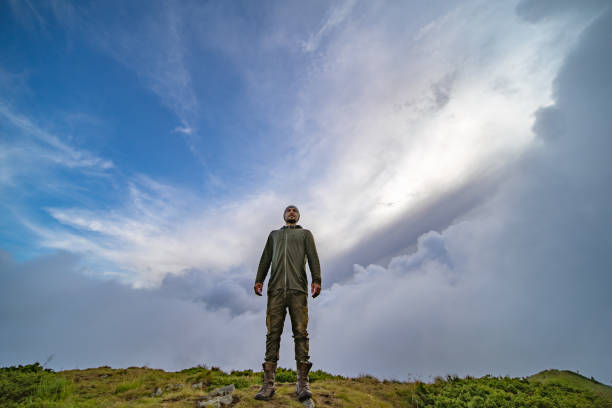 istock The man standing on the mountain on a cloudy sky background 1167722805