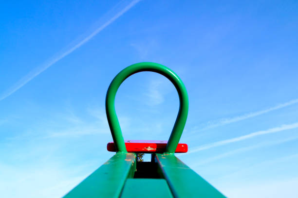 New childrens swing directed to the blue sky with white clouds. Equipment for the playground.