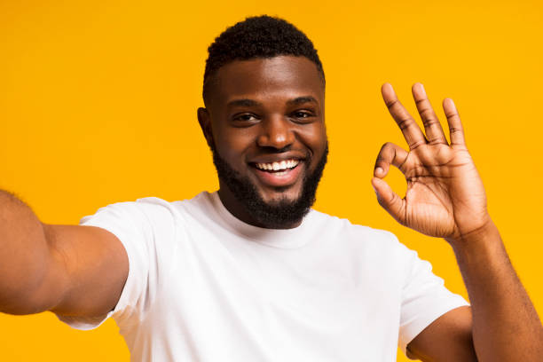 istock African man making selfie and showing ok sign at camera 1167724377