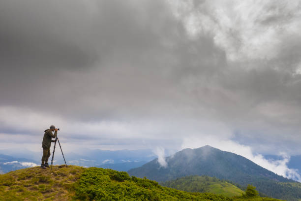 istock The photographer standing on the mountain with rainy clouds 1167724505