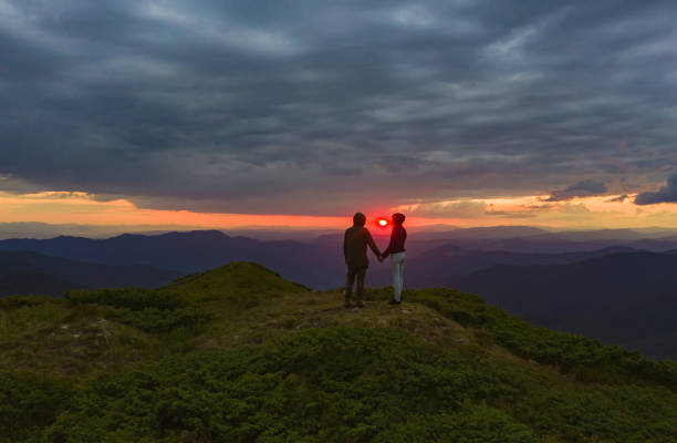 istock The couple standing on the bright sunset background 1167724580