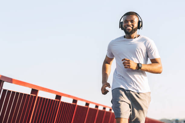 istock Smiling african american guy running along the bridge 1167724738