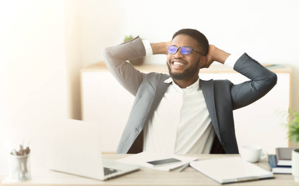 istock African businessman resting at office, sitting with hands behind head 1167724760