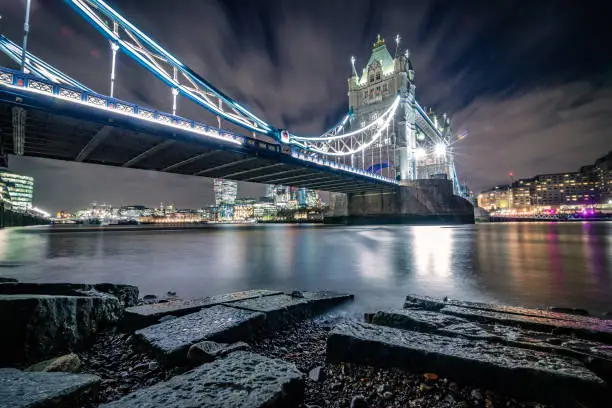 Panoramic detailed view with night illumination at Tower Bridge in City of London, England. Long exposure technique to capture the busy road traffic and constant tourist visiting this famous international landmark, connecting City of London directly to the Southwark bank (Unesco heritage site nowadays and build in 1894) . Shot on Canon full frame system with premium optics/lens for highest quality results from a tripod.