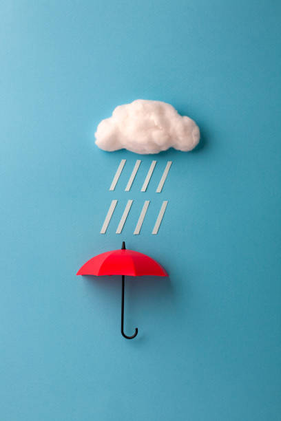 istock red umbrella under the cloud on sky blue background 1167729187