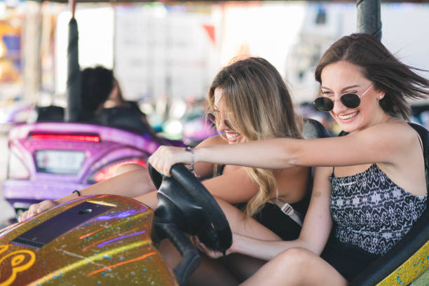 istock Two young women having a fun bumper car ride at the amusement park. 1167734020