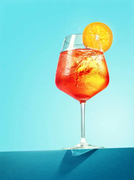 Glass of Spritz cocktail on blue background