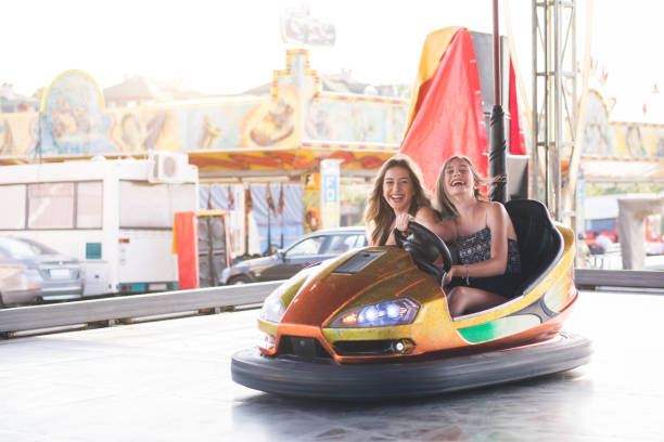 istock Two young women having a fun bumper car ride at the amusement park. 1167734151