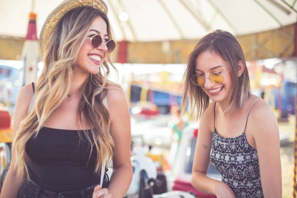 istock Two beautiful girls having fun at amusement park 1167734232