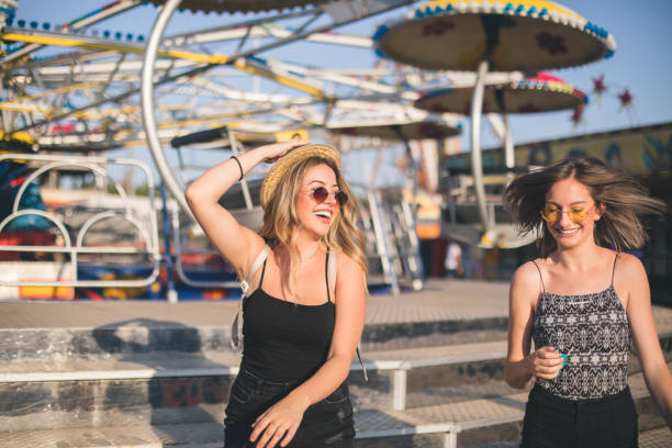 istock Two beautiful girls having fun at amusement park 1167734253