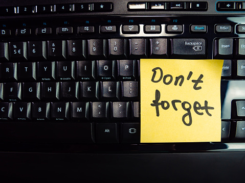 Yellow  note with  password  don't forget on  part of keyboard .  The scene is situated in a studio environment. The picture is taken with Panasonic GH5 camera.
