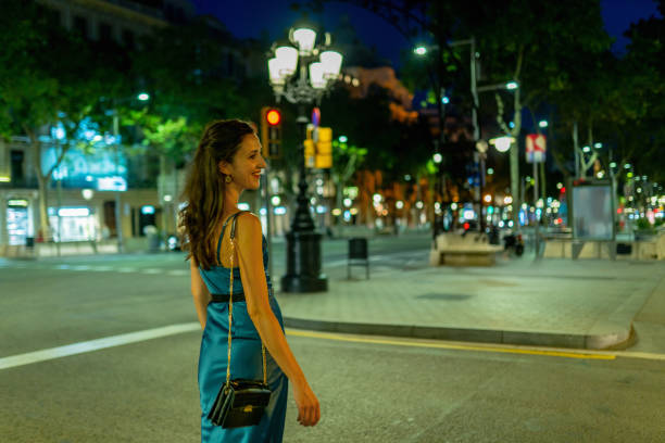 Elegant woman walking at Passeig de Gràcia at night stock photo