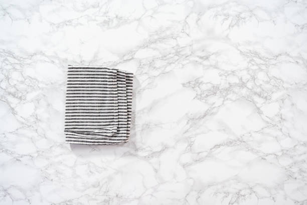 istock Kitchen towels with white and black stripes on the marble counter. 1167739193