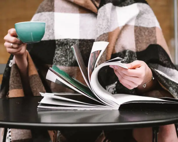 Photo of Reading magazine and drinking coffee