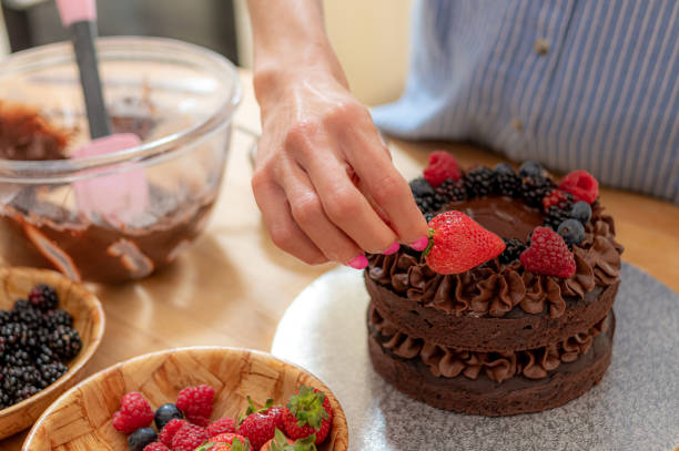 istock Placing a large strawberry on a vegan chocolate cake 1167743249