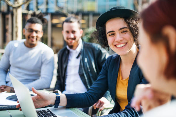 istock Group of young businesspeople using laptop outdoors in courtyard, start-up concept. 1167745328