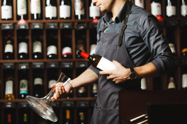 istock Bartender holds bottle of wine and unusual glass vessel 1167745356
