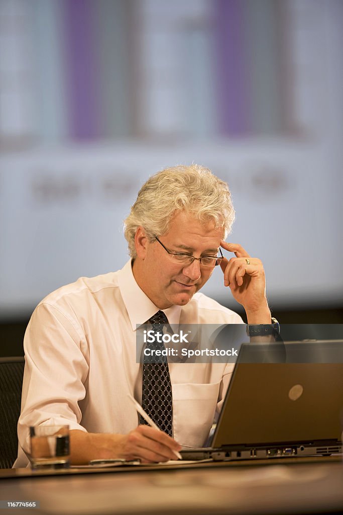 Businessman Working In His Office Photo of a handsome man working at his desk on his laptop. Business Stock Photo