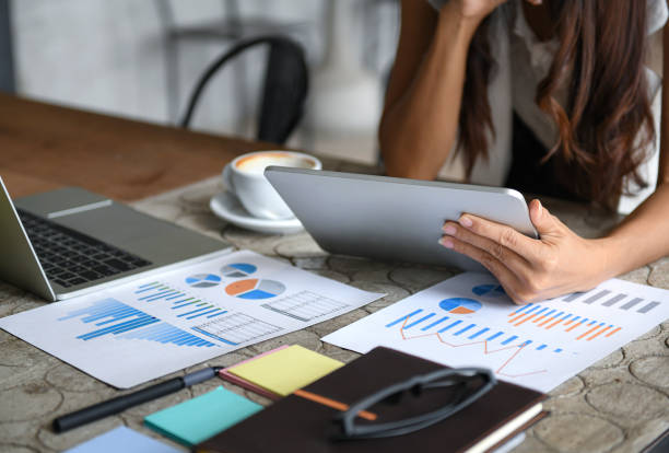 istock Female businessmen are using the tablet during leisure. Graphs, documents placed on the table. 1167746950