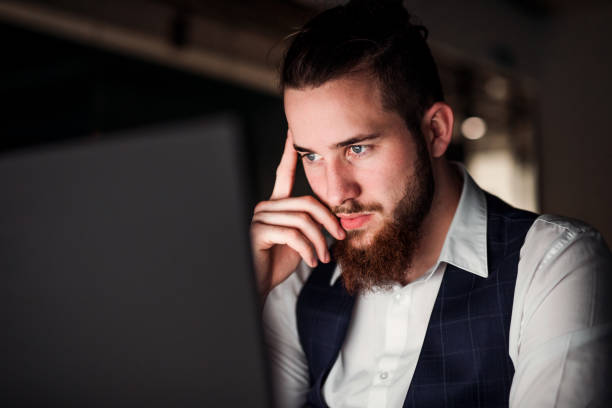istock A portrait of young businessman with computer in an office, working. 1167750197