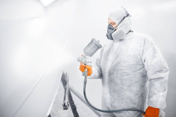 istock Male worker with mask and protective clothes painting car using spray compressor. 1167750306