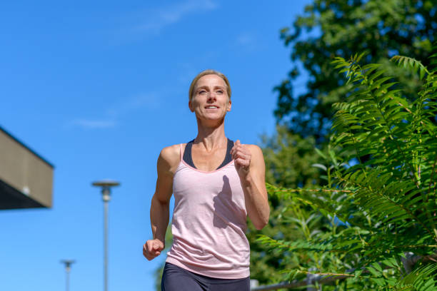 istock Woman smiling while running outdoors 1167750503