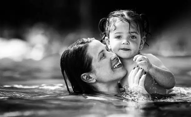 Photo of Mother and daughter having fun at the pool