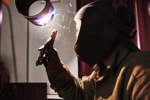 istock Male in face mask welds with welding 1167754791