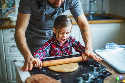 Family cooking Christmas cookies at the kitchen