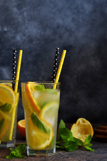 istock Summer cold drink - lemonade with orange and mint on a concrete background. 1167755594
