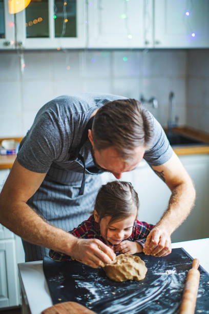 family cooking christmas cookies at the kitchen - pastry cutter family holiday child imagens e fotografias de stock