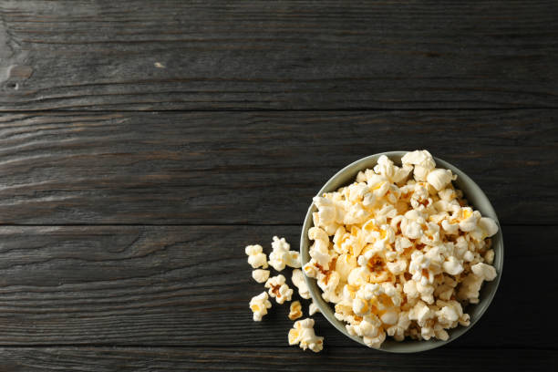 istock Bowl with popcorn on wooden background, space for text 1167758352