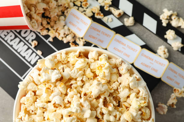 istock Clapperboard, tickets and buckets with popcorn on grey background, top view 1167758444