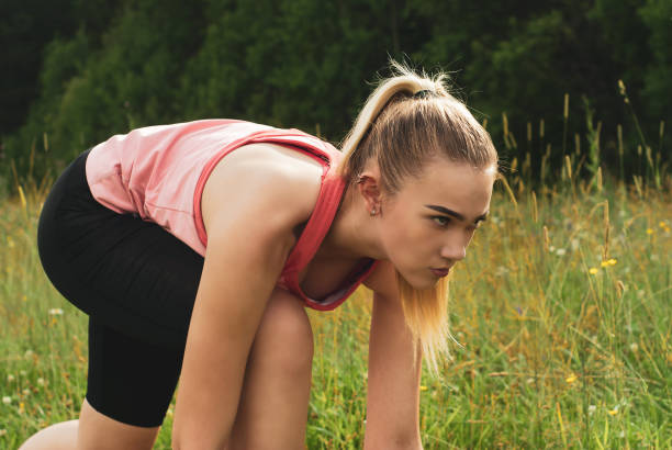 istock young woman in low start position before jogging in the park 1167758890