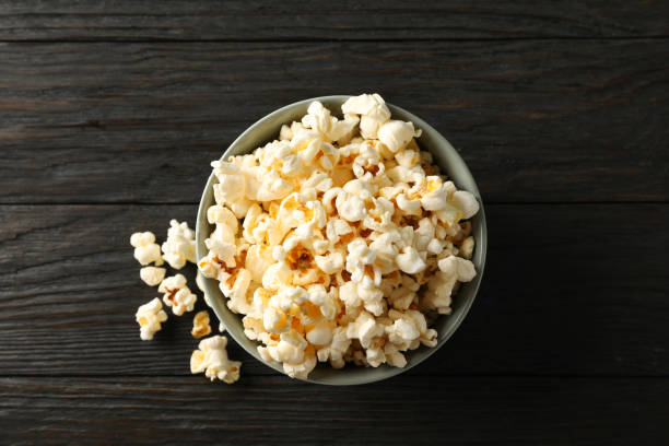 istock Bowl with popcorn on wooden background, space for text 1167759050