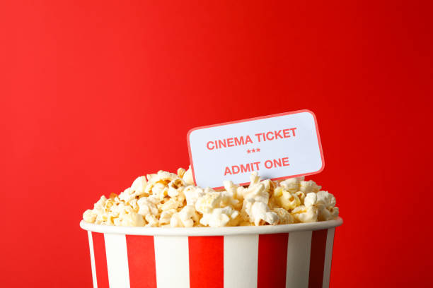 istock Striped bucket with popcorn and tickets against red background 1167761290