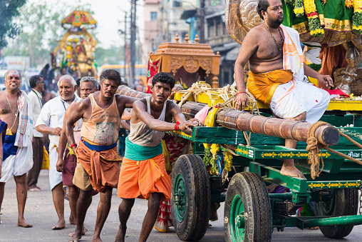 Madurai, India - August 23, 2018: Devotees pulling chariots with deities statues to Meenakshi Amman temple for the dormition ceremony. This Temple is dedicated to Meenakshi, an avatar form of Parvati