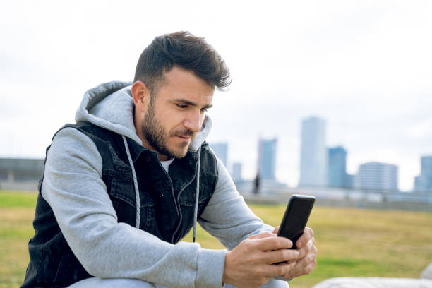 istock Casual man in sports clothes using smart phone in a park 1167764324